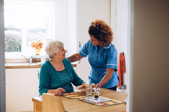 A carer talking to an elderly lady