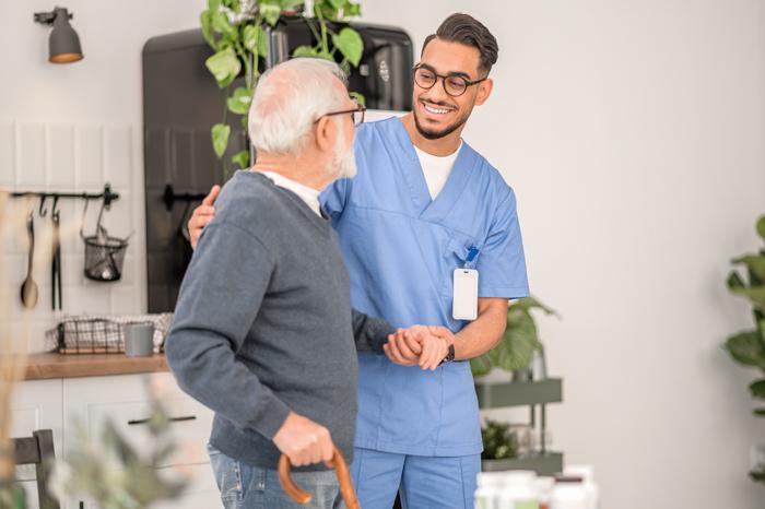 A carer helping an elderly man