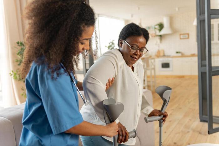 A carer helping a patient walk at home